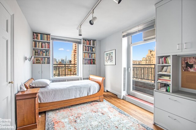 bedroom featuring access to exterior and light hardwood / wood-style flooring