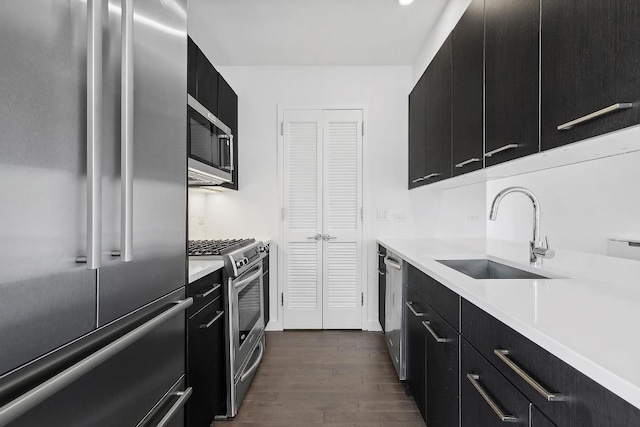 kitchen featuring dark wood-type flooring, stainless steel appliances, and sink