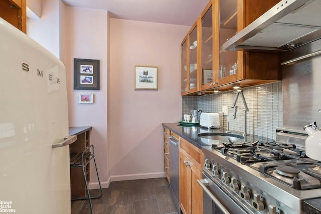 kitchen featuring decorative backsplash, appliances with stainless steel finishes, and wall chimney exhaust hood