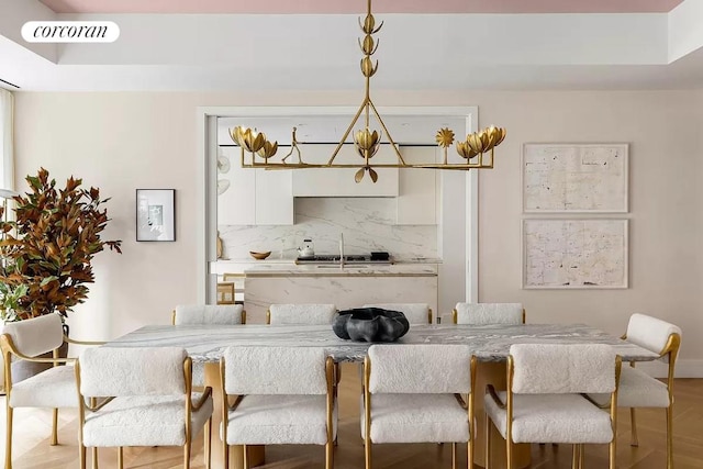 kitchen with light countertops, visible vents, hanging light fixtures, backsplash, and white cabinetry