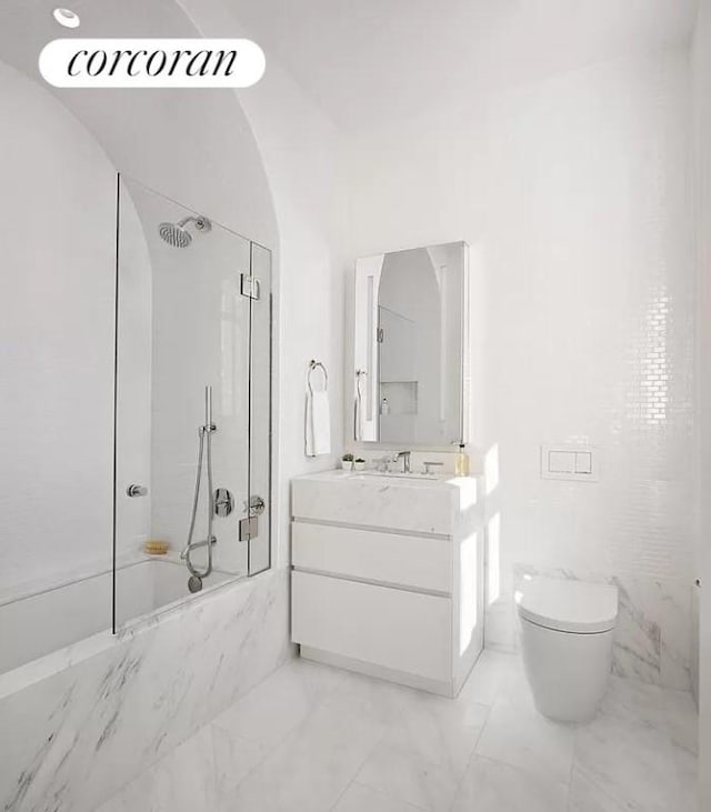 bathroom with toilet, marble finish floor, a marble finish shower, and vanity