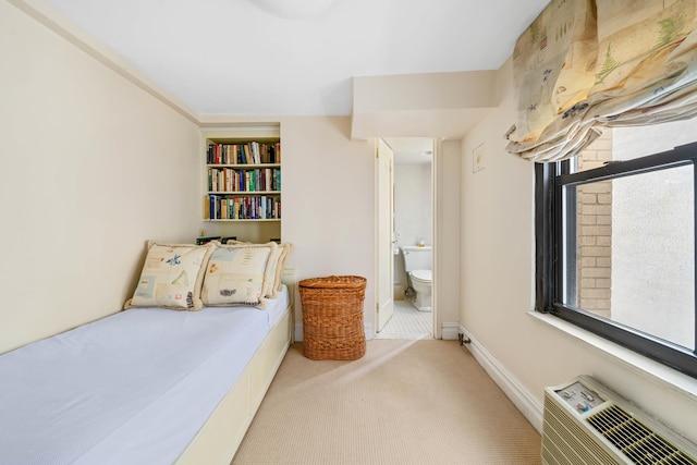 955 5th Ave Unit 2B, New York City, NY 10075 - bedroom with an AC wall unit, carpet floors, ensuite bath, and baseboards