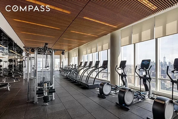 gym with floor to ceiling windows and a healthy amount of sunlight