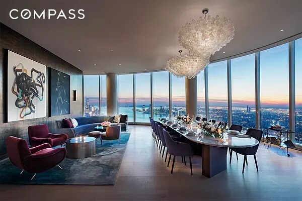 dining space with a notable chandelier, floor to ceiling windows, a water view, and wood finished floors