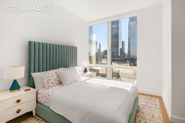 bedroom with a city view and baseboards