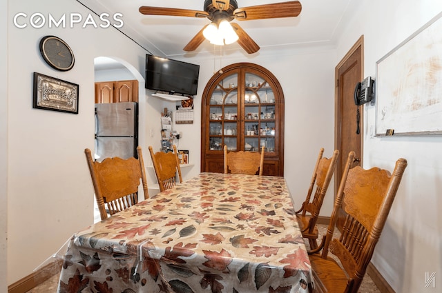 dining area with ceiling fan, baseboards, and crown molding