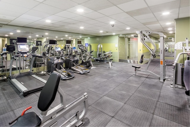 gym with a drop ceiling and baseboards