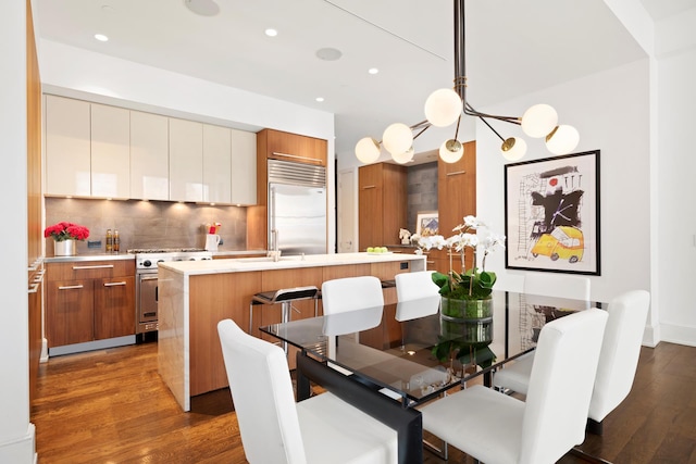 dining space with dark wood-style floors, recessed lighting, and a chandelier