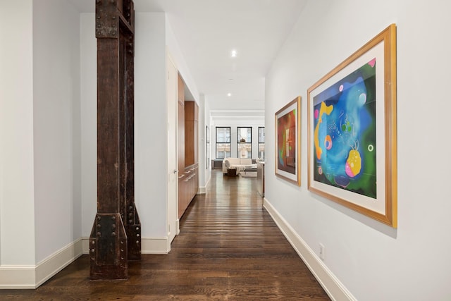 hall with dark wood-type flooring, baseboards, and recessed lighting
