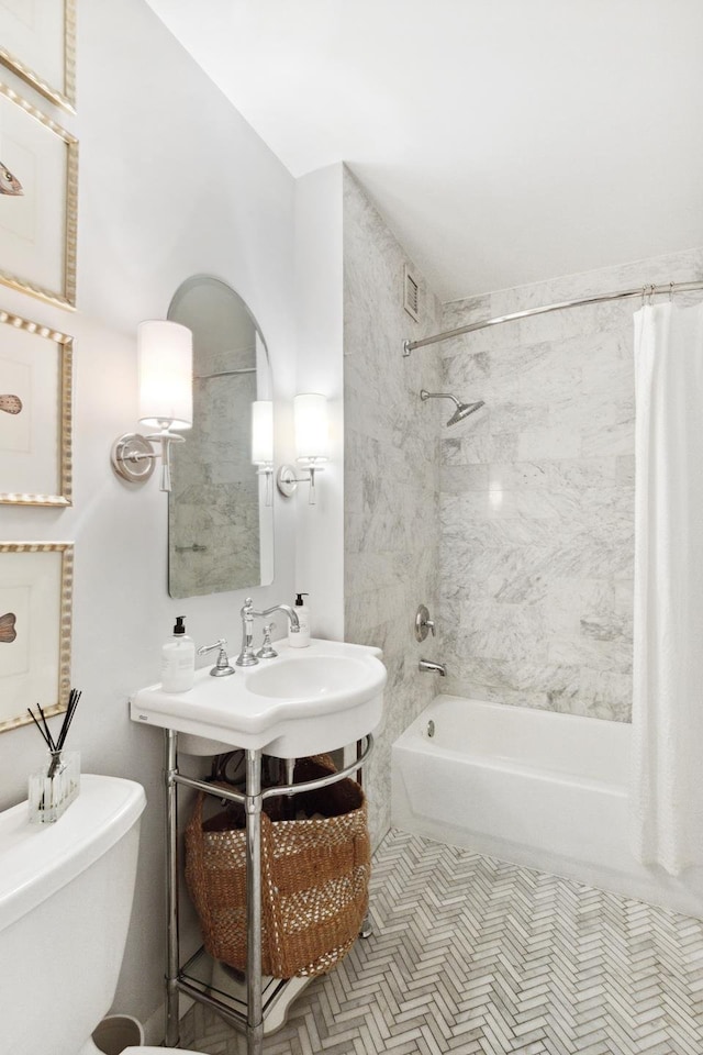 full bathroom featuring toilet, shower / tub combo, and visible vents