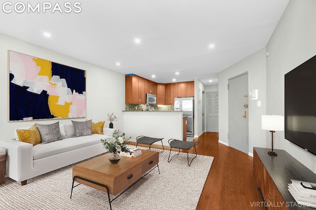 living room featuring sink and light hardwood / wood-style flooring