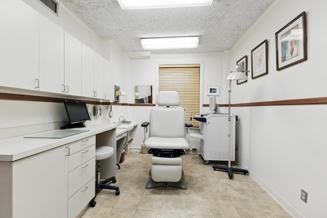 office area with built in desk and a textured ceiling