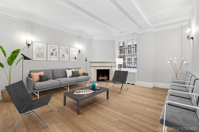 living room featuring a high end fireplace, beam ceiling, and wood-type flooring