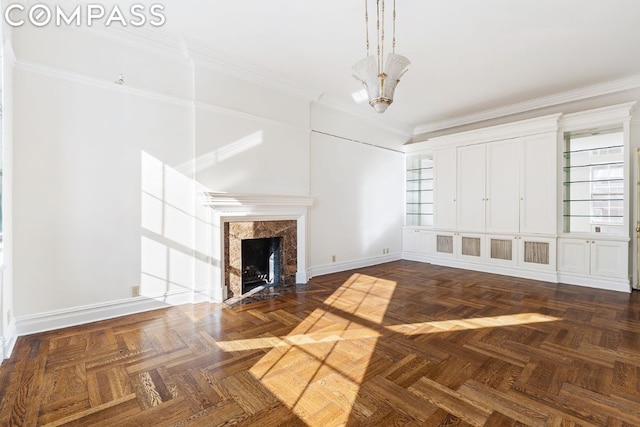 unfurnished living room with crown molding, a fireplace, and dark parquet floors