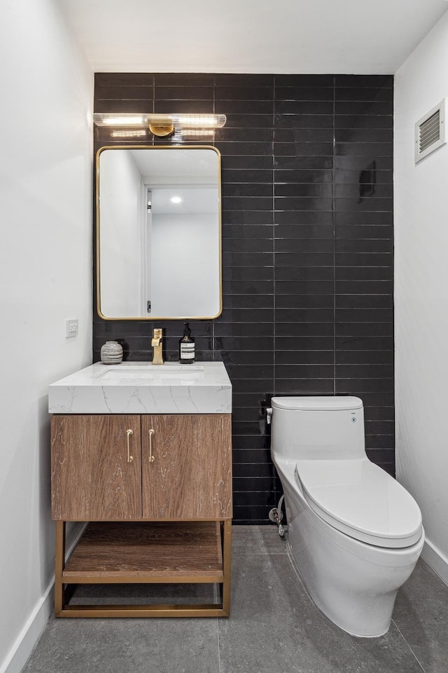 half bath with visible vents, toilet, vanity, and baseboards