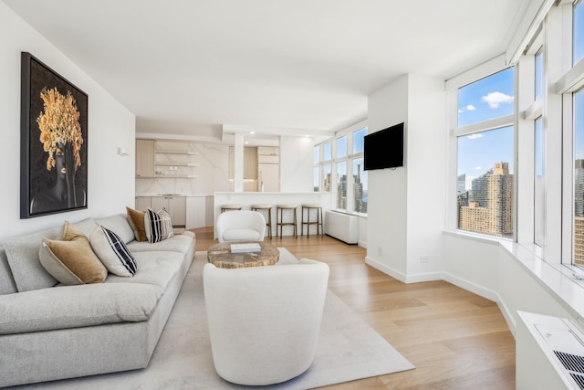 living area with light wood-style flooring and baseboards