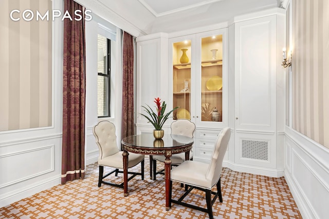 2 E 55th St Unit 822W24, New York City, NY 10022 - dining area featuring a decorative wall, light flooring, wainscoting, and crown molding
