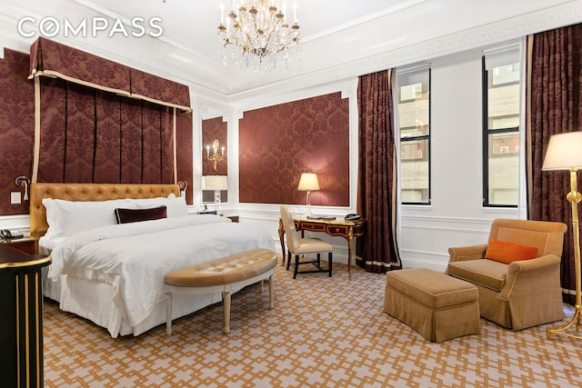 bedroom featuring a decorative wall, ornamental molding, carpet, and a chandelier