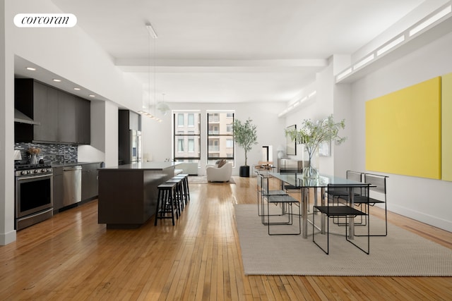 dining space featuring light wood finished floors, baseboards, visible vents, and recessed lighting