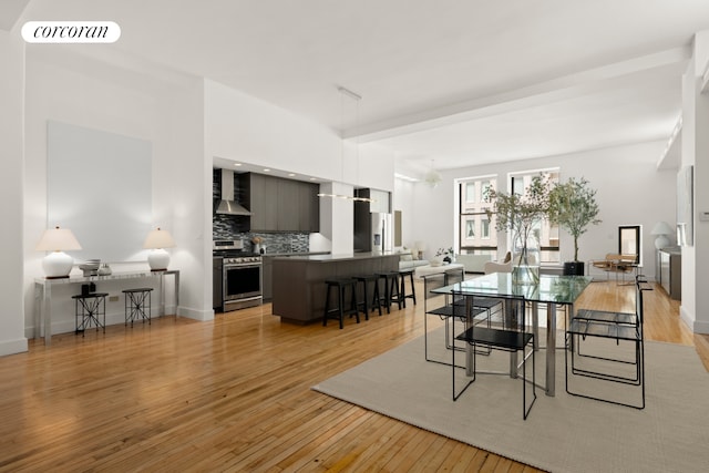 dining area featuring light wood-style floors, baseboards, and visible vents