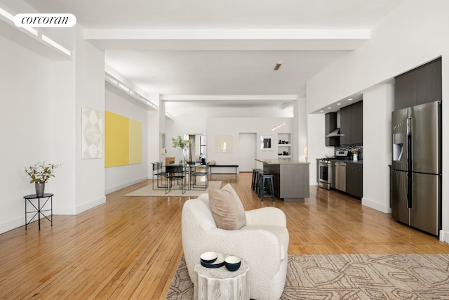 living room featuring light wood finished floors, visible vents, and baseboards