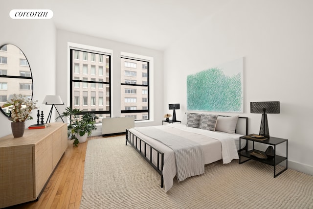 bedroom featuring baseboards, visible vents, and light wood finished floors