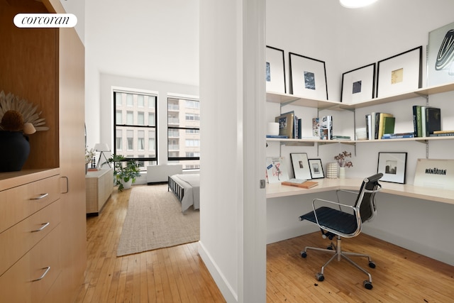 office area with baseboards, light wood-type flooring, and built in study area