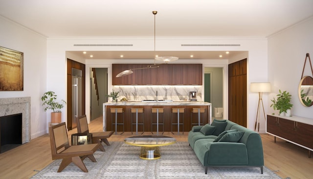 living room with light wood-type flooring, crown molding, a high end fireplace, recessed lighting, and baseboards