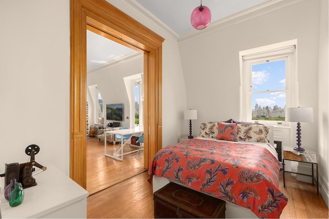 bedroom with ornamental molding and light wood-type flooring