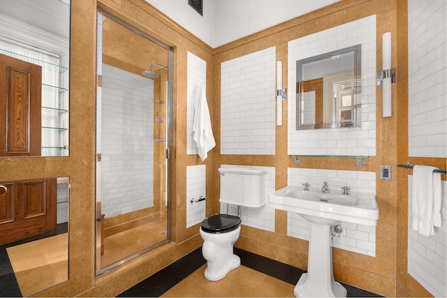 full bathroom featuring tile walls, a stall shower, toilet, and visible vents