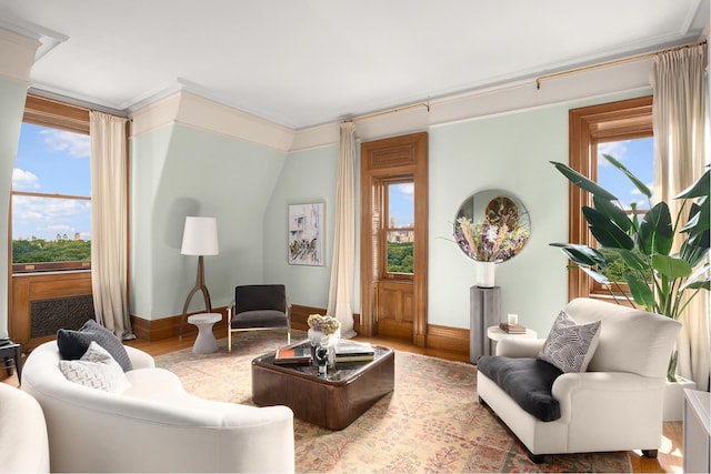 living room featuring crown molding, baseboards, and wood finished floors