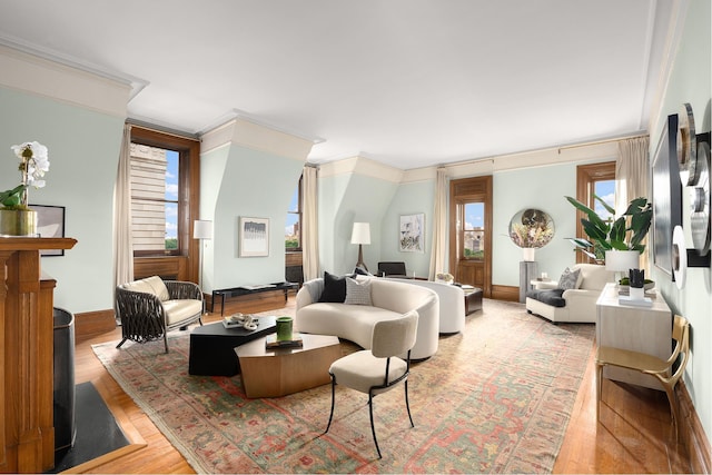 interior space featuring crown molding, baseboards, and light wood finished floors