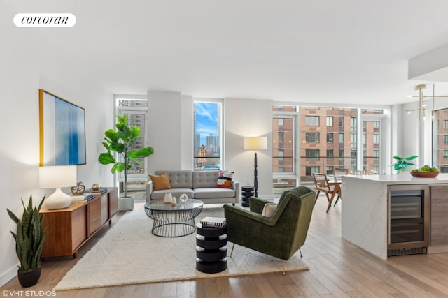 living room with floor to ceiling windows, wine cooler, and light hardwood / wood-style flooring