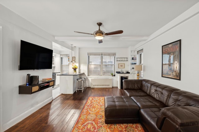 living room featuring baseboards, radiator, ceiling fan, dark wood-style flooring, and beamed ceiling