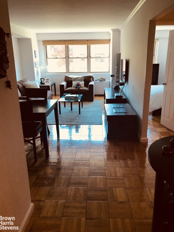 living room featuring ornamental molding and dark parquet floors