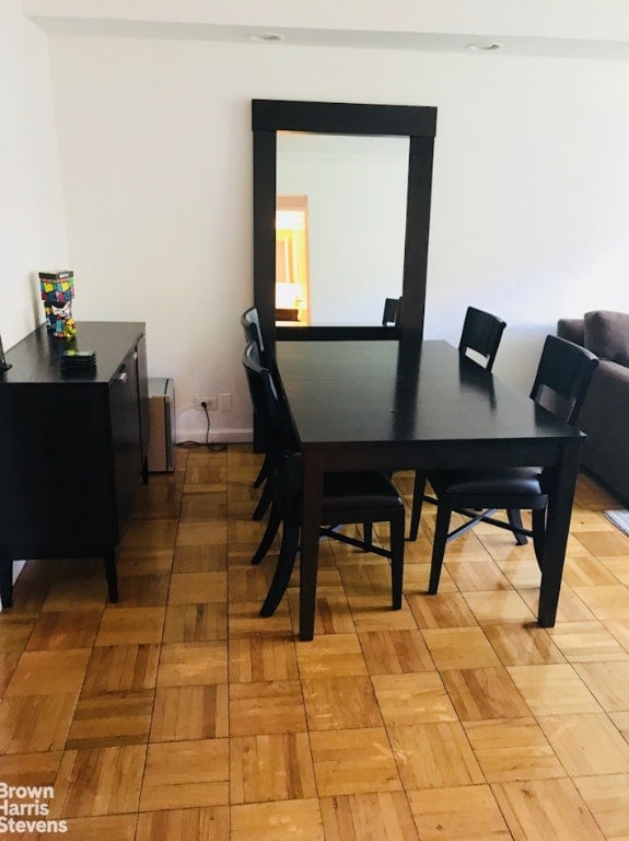 dining space with parquet flooring