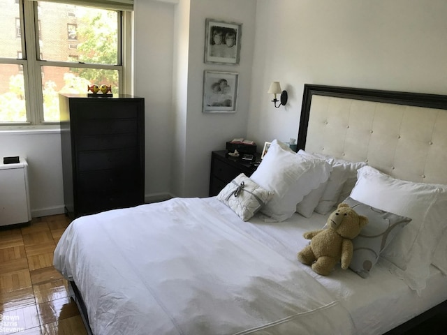 bedroom featuring multiple windows and dark parquet flooring