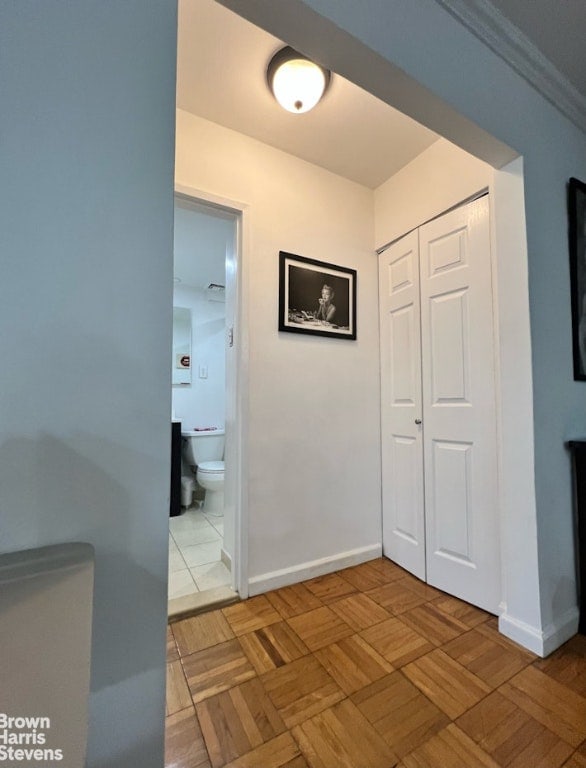 hallway featuring crown molding and parquet floors