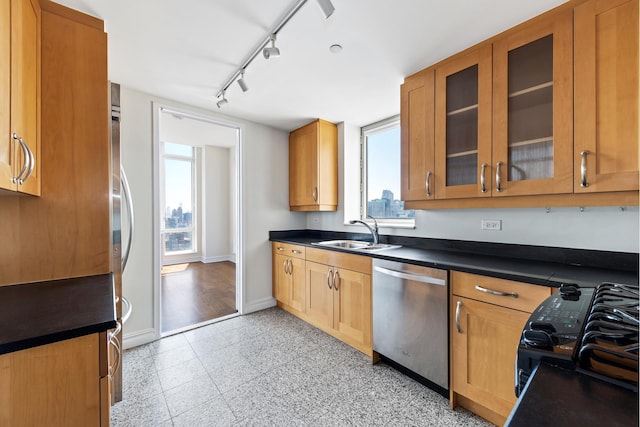 kitchen featuring a sink, dark countertops, baseboards, and stainless steel dishwasher