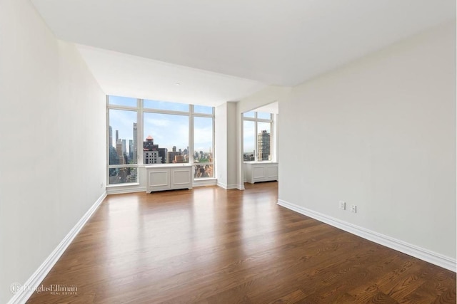 401 E 60th St Unit 38Ab, New York City, NY 10065 - unfurnished living room with dark wood-type flooring and a skyline view