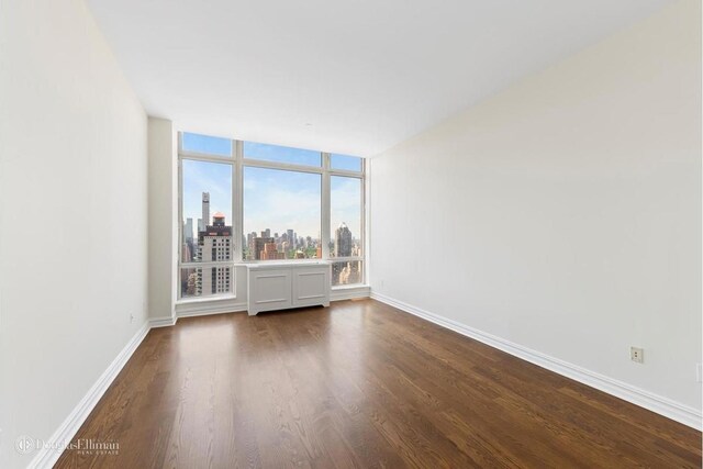 401 E 60th St Unit 38Ab, New York City, NY 10065 - empty room featuring dark wood finished floors and a skyline view