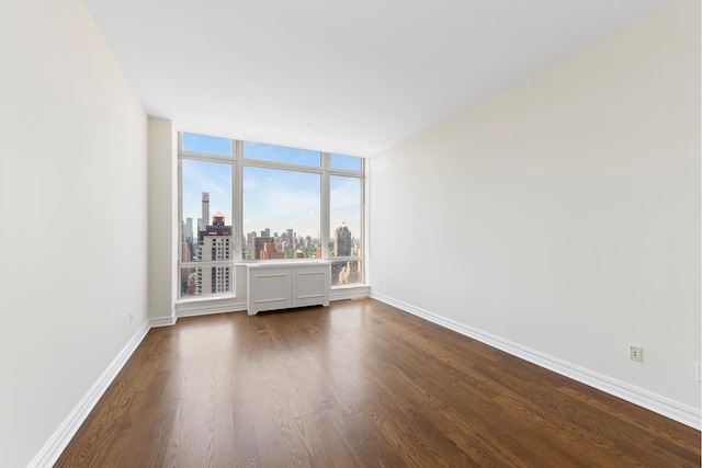 401 E 60th St Unit 38Ab, New York City, NY 10065 - spare room with a skyline view and dark wood-type flooring