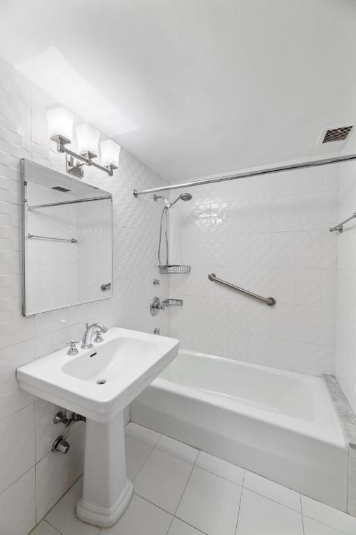 bathroom featuring tile walls, tile patterned floors, and tiled shower / bath combo