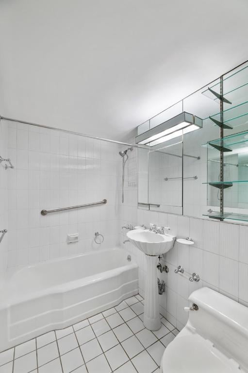 bathroom featuring toilet, tile walls, tile patterned flooring, and tiled shower / bath combo