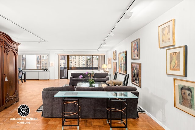 living room with rail lighting, a wealth of natural light, and baseboards