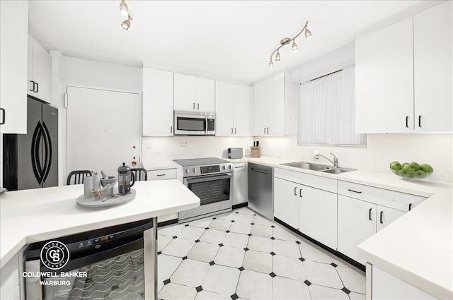 kitchen featuring light floors, stainless steel appliances, light countertops, white cabinets, and a sink