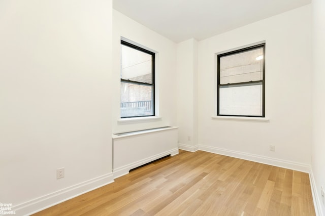 unfurnished room featuring baseboards and light wood-style floors