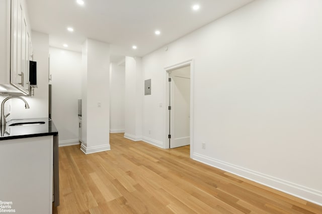 interior space with light wood finished floors, recessed lighting, baseboards, and a sink