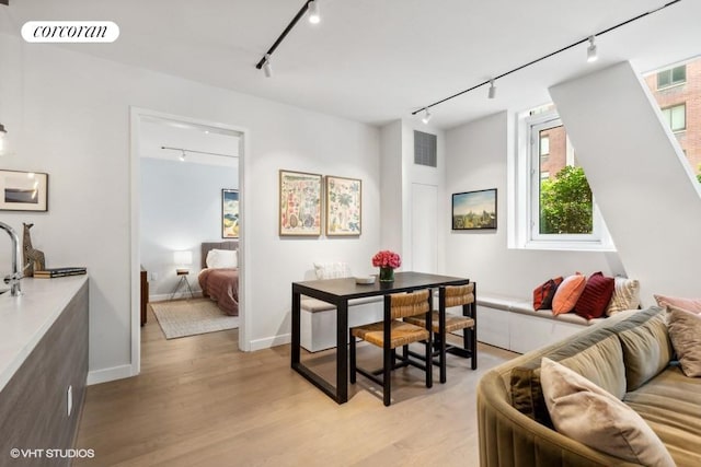 dining room featuring track lighting and light wood-type flooring