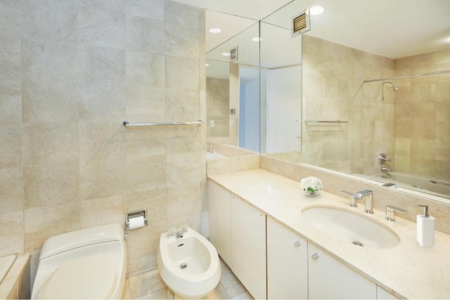 full bathroom featuring tile walls, toilet, vanity, and a bidet